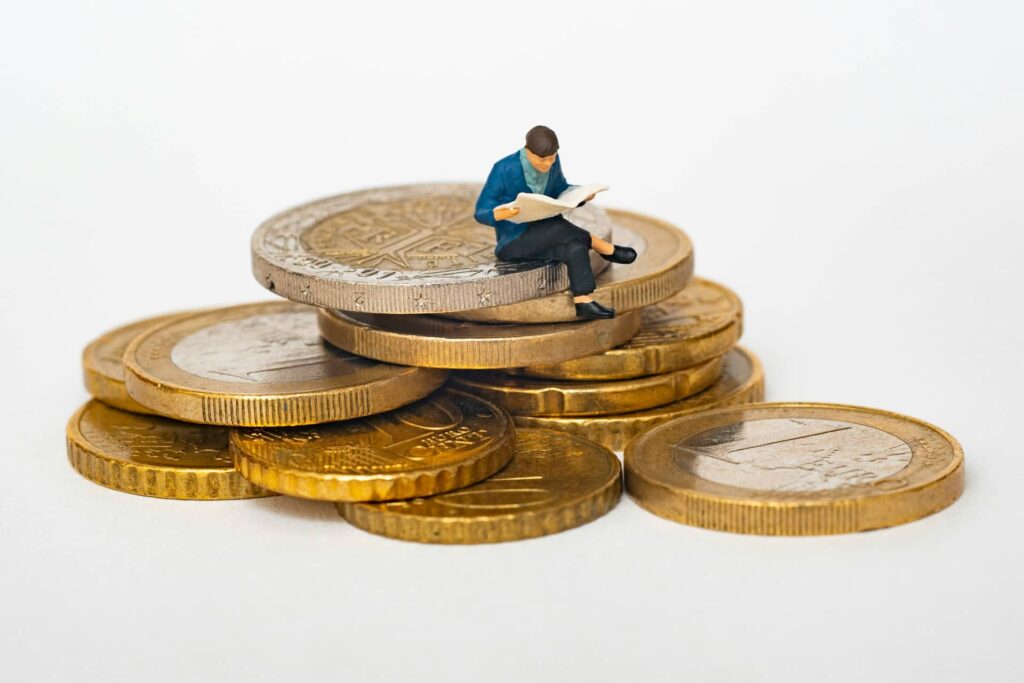 お金の上に人形が座っている画像